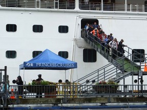 Passengers of the Emerald Princess cruise ship disembark on Wednesday, July 26, 2017, in Juneau, Alaska, hours after arriving at port. A domestic dispute aboard the cruise ship led to the death of a 39-year-old Utah woman, and the FBI is investigating what happened in U.S. waters off Alaska, the agency said Wednesday. (AP Photo/Becky Bohrer)