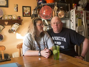 In this Friday, July 7, 2017, photo, Tammie Jackson, and her husband, Travis Jackson of Butte, Mont., discuss their Medicaid program benefits at their home in Helena, Mont. Tammie, who was uninsured until she enrolled in Montana's expanded Medicaid program, receives medical care for a host of health issues, including a back injury that has kept from returning to her job cleaning hotel rooms. Montana officials who tout the dramatic drop in the state's medically uninsured due to expanded Medicaid, are now under pressure to reduce the number of new Medicaid enrollees. (AP Photo/Bobby Caina Calvan)