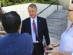 Birney Bervar, center, addresses reporters outside the federal courthouse in Honolulu on Monday, July 10, 2017. Bervar was appointed the attorney for Ikaika Kang, a 34-year-old active duty soldier who has been accused of trying to aid the Islamic State. (AP Photo/Caleb Jones)