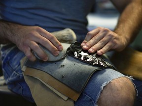 In this June 1, 2017, photo, Metin Eren, an archaeologist at Kent State University, flakes obsidian in Kent, Ohio. Eren runs a newly-opened laboratory which makes replicas of ancient arrows, knives, and pottery to be shot, crushed, and smashed. It's allowing researchers to learn about engineering techniques of the first native Americans without destroying priceless genuine relics in the process. (AP Photo/Dake Kang)