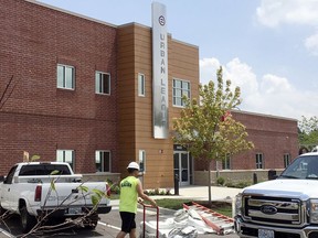In this Tuesday, July 25, 2017, photo, a construction worker helps with finishing touches at the new Ferguson Empowerment Center in Ferguson, Mo. The new $3 million center will house an Urban League office focused on job training and placement. A dedication ceremony is planned Wednesday morning, July 26. (AP Photo/Jim Salter)