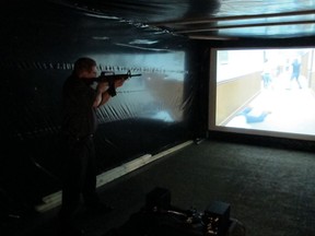Deputy Scott Cultice of the Clark County Sheriff's Office takes aim in a firearms training simulator at the county fair on Wednesday, July 26, 2017, in Springfield, Ohio. The sheriff rented the simulator to offer as a free exhibit, hoping it will help the public better understand how quickly officers must decide whether to use lethal force. (AP Photo/Kantele Franko)