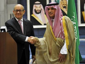 In this Saturday, July 15, 2017 photo released by Saudi Press Agency, Saudi Foreign Minister Adel al-Jubeir, right, shakes hands with France Foreign Minister Jean-Yves Le Drian during a join press conference in Jiddah, Saudi Arabia. France's foreign minister on Saturday called on Qatar's neighbors to immediately lift measures impacting thousands of people in the Gulf, becoming the latest foreign diplomat to visit the region and attempt to help find a resolution to a crisis that has dragged on for more than a month. (Saudi Press Agency via AP)