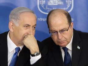 FILE - In this Feb. 16, 2015 file photo, Israeli Prime Minister Benjamin Netanyahu, left, speaks with former Israeli Defense Minister Moshe Yaalon, during a ceremony at the Prime Minister's office in Jerusalem. A former defense minister who was fired by Benjamin Netanyahu says the Israeli prime minister is "corrupt" and should resign over an alleged conflict of interest related to the purchase of German submarines. (AP Photo/Sebastian Scheiner, File)