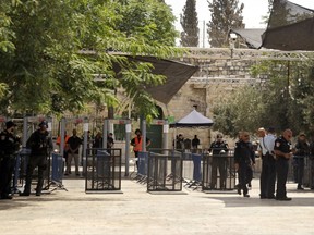 Israeli border police officers stand near newly installed cameras at the entrance to the Al Aqsa Mosque compound, in Jerusalem's Old City, Sunday, July 23, 2017. Israel installed the cameras Sunday at the entrance to a sensitive Jerusalem holy site, as officials began indicating it was considering "alternatives" to the metal detectors at the contested shrine that set off a weekend of violence and raised tensions in the region. (AP Photo/Mahmoud Illean)