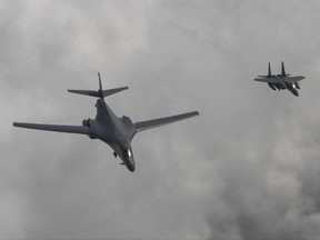 In this photo provided by South Korea Defense Ministry, a U.S. Air Force B-1B bomber, left, flies with a South Korean fighter jet F-15K over the Korean Peninsula, South Korea, Sunday, July 30, 2017.
