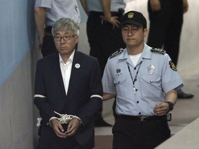 Former Culture Minister Kim Jong-deok, left, arrives at Seoul Central District Court in Seoul, South Korea, Thursday, July 27, 2017. A South Korean court has sentenced the former presidential chief of staff and the former culture minister to prison for blacklisting thousands of artists deemed unfriendly to ousted president Park Geun-hye and denying them state support. (AP Photo/Ahn Young-joon)