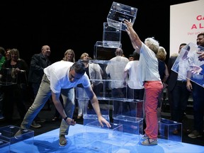 People hold ballot boxes after a meeting in Barcelona, Spain, Tuesday, July, 4, 2017. Catalonia's regional government chose October 1st for a referendum on a split from Spain, stepping up the confrontation with central authorities who see the vote as illegal. (AP Photo/Manu Fernandez)
