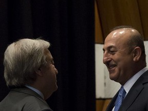 UN Secretary-General Antonio Guterres, left, talks with Turkish Foreign Minister, Mevlut Cavusoglu, right, prior to  a new round of the conference on Cyprus under the auspices of the United Nations, in Crans-Montana, Switzerland, Friday, June 30, 2017. (Jean-Christophe Bott/Keystone via AP)