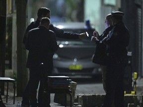 Australian Federal Police and NSW Police officers work in the Surry Hills suburb of Sydney, Australia on Saturday, July 29, 2017. Law enforcement officials raided properties in several Sydney suburbs and arrested four men on suspicion of plotting a terrorist attack related to a bomb plot involving aircraft, officials said. (Sam Mooy/AAP Image via AP)