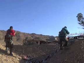 This frame grab from video released on May 26, 2017 and provided by the government-controlled Syrian Central Military Media, shows Syrian forces fires their weapons at Islamic State position, in Homs provence, Syria. Arabic reads, "Central Military Media, Homs, Syria." As the noose tightens on Islamic State militants in Syria, the United States and the coalition it leads will face a choice with no great options: it will be difficult to defeat the militants without cooperating with the internationally ostracized government of President Bashar Assad _ but doing so might be seen as legitimizing his continued rule. (Syrian Central Military Media, via AP)