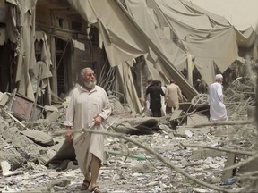 FILE - This undated file frame grab from video posted online May 29, 2017, by the Aamaq News Agency, a media arm of the Islamic State group, shows people inspecting damage from airstrikes and artillery shelling in the northern Syrian city of Raqqa, the de facto capital of the IS. The U.S. military said Tuesday, July 4, 2017, that allied Syrian forces have breached the wall around Raqqa's Old City, where they are fighting to drive Islamic State militants from the extremists' self-declared capital. (Aamaq News Agency via AP, File)