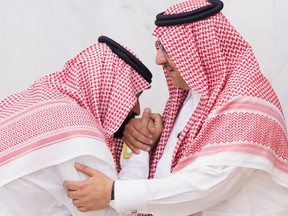 In this Wednesday, June 21 , 2017 photo, Mohammed bin Salman, newly appointed as crown prince, left, kisses the hand of Prince Mohammed bin Nayef at royal palace in Mecca, Saudi Arabia.