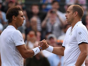 Gilles Muller (right) shakes hands with Rafael Nadal after their match at Wimbledon on July 10.