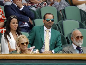 FILE - In this Friday, July 7, 2017 file photo golfer Sergio Garcia, wearing his green Masters jacket, centre and fiancee Angela Akins sit in the Royal Box on day five at the Wimbledon Tennis Championships in London. When Masters champion Sergio Garcia sat in the Royal Box at Wimbledon last week, he showed up in his green jacket from Augusta National. Seemed fitting. The tennis and golf tournaments seem to be each other's counterparts in many ways, starting with the reverence in which they're held by many in the sports. (AP Photo/Alastair Grant, File)