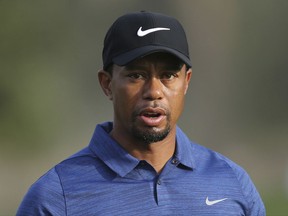 FILE - In this Feb. 2, 2017 file photo, Tiger Woods reacts on hole 10th during the 1st round of the Dubai Desert Classic golf tournament in Dubai, United Arab Emirates. Woods has checked out of the clinic where he went to get help dealing with pain medications, saying he will "continue to tackle this going forward." The treatment follows the golfer's arrest on a DUI charge after he was found asleep at the wheel in Jupiter, Fla., around 2 a.m. on May 29, 2017. (AP Photo/Kamran Jebreili, File)