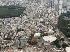 In this July 23, 2017 photo, Japan's new National Stadium, foreground, is seen under construction in Tokyo.  Japan has begun its three-year countdown to the 2020 Olympic Games in Tokyo with relays, concerts and dancing meant to help drum up public enthusiasm for the event. The 2020 Games will be Japan's first summer Olympics since the 1964 games in Tokyo. After a rocky start, organizers are gearing up to get the public more involved. (Yohei Kanasashi/Kyodo News via AP)