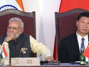 FILE - In this Oct. 16, 2016, file photo, Indian Prime Minister Narendra Modi, left, and Chinese President Xi Jinping listen to a speech during the BRICS Leaders Meeting with the BRICS Business Council in Goa, India. India and China have faced off frequently since fighting a bloody 1962 war that ended with China seizing control of some territory. India's army chief warned in July 2017 that India's army was capable of fighting "2 1/2 wars" if needed to secure its borders. The dispute was discussed briefly without resolution by Xi and Modi on the sidelines of the G-20 summit in Hamburg, Germany. (AP Photo/Manish Swarup, File)