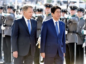 Japanese Prime Minister Shinzo Abe, right, walks with Finnish President Sauli Niinist during a welcome ceremony for Abe in front of the Presidential Palace in Helsinki, Finland, Monday, July 10, 2017. (Jussi Nukari/Lehtikuva via AP)