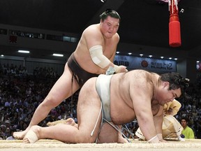 Mongolian grand champion Hakuho, left, topples champion Takayasu to win their bout during the Nagoya Grand Sumo Tournament in Nagoya, central Japan, Friday, July 21, 2017. Hakuho set a record of 1,048 carrier match wins in sumo history. (Yoshiaki Sakamoto/Kyodo News)
