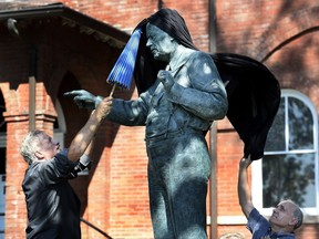 Actor John de Lancie, left, and musician Dan Barker remove the drape off the Clarence Darrow statue during the dedication ceremony in front of the Rhea County Courthouse, Friday, July 14, 2017, in Dayton, Tenn. Darrow was the lawyer who defended John T. Scopes, a biology teacher, who fought Tennessee's law banning the teaching of evolution. (AP Photo/Mark Zaleski)