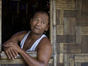In this April 8, 2017 photo, Myint Naing looks out from his sister's house in Mudon, Mon State, Myanmar. Naing, one of the enslaved fishermen who was freed more than two years ago, have been forced to travel hundreds of miles to find back-breaking labor that pays only a few dollars a day. He dreams of opening a little snack shop to help contribute to the family's income, but there is no money to start it. (AP Photo/Thein Zaw)