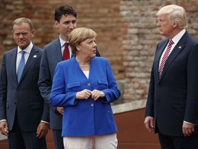 FILE - In this May 26,m 2017 file photo, German Chancellor Angela Merkel, accompanied by European Council President Donald Tusk, Canadian Prime Minister Justin Trudeau, talks with President Donald Trump during a family photo with G7 leaders at the Ancient Greek Theater of Taormina in Taormina, Italy. President Donald Trump will learn this week whether he gets a second chance to make a first impression as he returns to Europe and has his first encounter with Russia's Vladimir Putin.  (AP Photo/Evan Vucci, File)