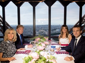 French President Emmanuel Macron, his wife Brigitte Macron, President Donald Trump and First Lady Melania Trump attend a dinner at Le Jules Verne Restaurant on the Eiffel Tower in Paris, on July 13, 2017.