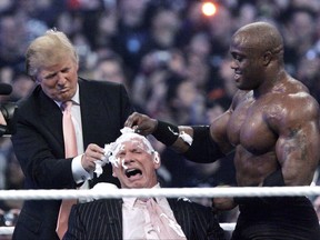 In this April 1, 2007 photo, Donald Trump, left, and Bobby Lashley, right shave the head of Vince McMahon after Lashley defeated Umaga at Wrestlemania 23 at Ford Field in Detroit.
