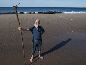 Fred Penner stands with one of his larger walking sticks on the beach on the 7th day of leg 5 of the C3 expedition at Wonderstands beach, Labrador, July 18, 2017. The remote beach is thought to be one of the longest beaches in the world.