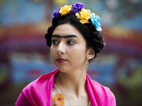 In this Thursday July 6, 2017 photo, Alicia Cano waits outside for the attempt to break the Guinness World Record for the largest gathering of people dressed as Frida Kahlo in one location at the Dallas Museum of the Art in Dallas. The Dallas Museum of Art says more than 5,000 people attended the celebration Thursday night marking the 110th birthday of the artist. (Tailyr Irvine/The Dallas Morning News via AP)