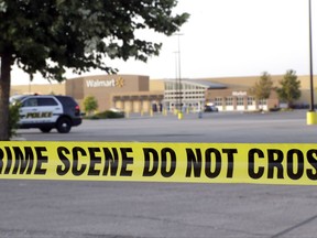 San Antonio police officers investigate the scene where eight people were found dead in a tractor-trailer loaded with at least 30 others outside a Walmart store in stifling summer heat in what police are calling a horrific human trafficking case, Sunday, July 23, 2017, in San Antonio. (AP Photo/Eric Gay)