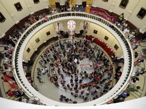 Protesters gather in the Texas Capitol Rotunda as State lawmakers begin a special legislative session called by Republican Gov. Greg Abbott in Austin, Texas, Tuesday, July 18, 2017. Immigrant rights groups plan to increase protests of the new law that allows police to inquire about peoples' immigration status, while LGBT activists bitterly oppose "bathroom bill" proposals. (AP Photo/Eric Gay)