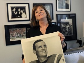 In this Wednesday, July 26, 2017 photo, Lise Hudson poses with photos of her husband, Jim Hudson, who played football for the University of Texas and the New York Jets in the 1960's, at her home in Austin, Texas. After his death, researchers found that Hudson suffered from stage IV chronic traumatic encephalopathy, the highest level of the brain disease. (AP Photo/Eric Gay)