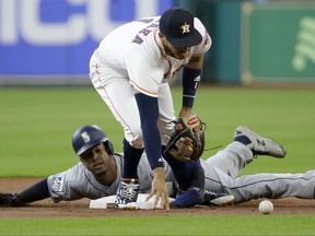 Seattle Mariners' Robinson Cano is safe at second base as Houston Astros' Carlos Correa reaches for the ball during the first inning of a baseball game Monday, July 17, 2017, in Houston. (Melissa Phillip/Houston Chronicle via AP)