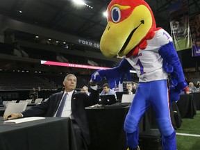 Big 12 commissioner Bob Bowlsby fist bumps the Kansas Jayhawks mascot before speaking to reporters during the Big 12 NCAA college football media day in Frisco, Texas, Monday, July 17, 2017. (AP Photo/LM Otero)