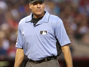 FILE - In this April 8, 2017 file photo, MLB umpire Angel Hernandez (55) is seen in the first inning during a baseball game between the Arizona Diamondbacks and the Cleveland Indians in Phoenix. Hernandez, a big league umpire for nearly a quarter-century, sued Major League Baseball on Monday, July 3, 2017, alleging race discrimination. In a complaint filed in U.S. District Court in Cincinnati, Hernandez, 55, who was born in Cuba, alleges MLB chief baseball officer Joe Torre "has a history of animosity towards Hernandez stemming from Torre's time as manager of the New York Yankees." (AP Photo/Rick Scuteri, File)
