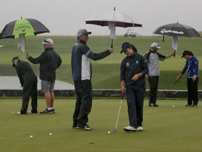 Players putt on the practice green atf the U.S. Women's Open Golf tournament Friday, July 14, 2017, in Bedminster, N.J. A rain delay Thursday pushed back the start of the second round. (AP Photo/Seth Wenig)