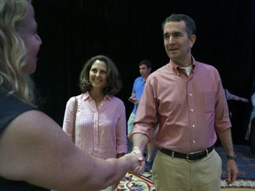 Democratic gubernatorial candidate Lt. Gov. Ralph Northam, right, and his wife Pam, center, are greeted by Virginia Bar Association Executive Director Yvonne C. McGhee, left, at the Omni Homestead Resort in Hot Springs, Va., Saturday, July 22, 2017 where Northam will debate withGOP gubernatorial candidate Ed Gillespie at the Virginia Bar Association meeting.   (Bob Brown/Richmond Times-Dispatch via AP)