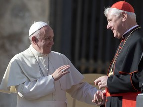 In this Wednesday, Nov. 19, 2014 file photo, Pope Francis talks with Cardinal Gerhard Ludwig Mueller at the end of his weekly general audience, in St. Peter's Square at the Vatican.