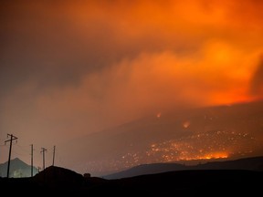 A wildfire burns on a mountain in the distance east of Cache Creek, B.C., in the early morning hours of Monday July 10, 2017.