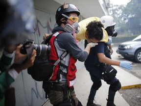 Medics carry a demonstrator that was injured during protests, to safety, in Caracas, Venezuela, Saturday, July 1, 2017. Demonstrators are taking the the streets after three months of continued protests that has seen the country's chief prosecutor Luisa Ortega barred from leaving the country and her bank accounts frozen, by the Supreme Court following her mounting criticisms of President Nicolas Maduro. (AP Photo/Ariana Cubillos)