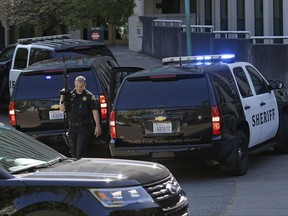 A Thurston County Sheriff's deputy walks with a gun after a lockdown at the state Capitol campus in Olympia, Wash. was lifted, Wednesday, July 12, 2017. The Washington State Patrol said in an email alert that troopers conducted a thorough search of buildings on campus Wednesday after reports of suspicious noises, but that nothing was found. (AP Photo/Ted S. Warren)