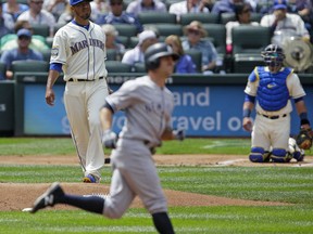 Seattle Mariners starting pitcher Yovani Gallardo, left, and catcher Carlos Ruiz watch as New York Yankees' Brett Gardner rounds the bases after he hit a lead-off home run in the first inning of a baseball game, Sunday, July 23, 2017, in Seattle. (AP Photo/Ted S. Warren)