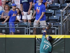 New York Mets fans watch as Seattle Mariners right fielder Mitch Haniger leaps for but cannot reach a two-run home run hit by New York Mets' Jay Bruce in the first inning of a baseball game, Friday, July 28, 2017, in Seattle. (AP Photo/Ted S. Warren)