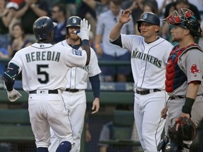 Seattle Mariners' Guillermo Heredia (5) is greeted at the plate as Boston Red Sox catcher Christian Vazquez watches after Heredia hit a three-run home run during the second inning of a baseball game Tuesday, July 25, 2017, in Seattle. (AP Photo/Ted S. Warren)