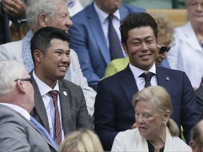 Japanese golfers Hideki Matsuyama, left, and Hideto Tanihara, right, take their seats on Centre Court on day nine at the Wimbledon Tennis Championships in London, Wednesday, July 12, 2017. (AP Photo/Tim Ireland)