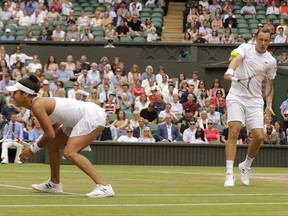 Finland's Henri Kontinen and Britain's Heather Watson return to Britain's Jamie Murray and Switzerland's Martina Hingis during the Mixed Doubles final match on day thirteen at the Wimbledon Tennis Championships in London Sunday, July 16, 2017. (AP Photo/Alastair Grant)