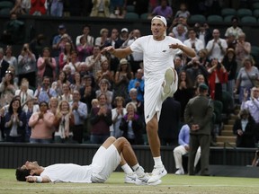 Poland's Lukasz Kubot, right, and Brazil's Marcelo Melo who lies on the floor celebrate after defeating Austria's Oliver Marach, and Croatia's Mate Pavic in the Men's Doubles final match on day twelve at the Wimbledon Tennis Championships in London, Saturday, July 15, 2017. (AP Photo/Kirsty Wigglesworth)