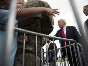 President Donald Trump greats members of the military and others as he arrives on Air Force One at Raleigh County Memorial Airport, in Beaver, W.Va., Monday, July 24, 2017, en route to the 2017 National Scout Jamboree in Glen Jean, W.Va.. (AP Photo/Carolyn Kaster)